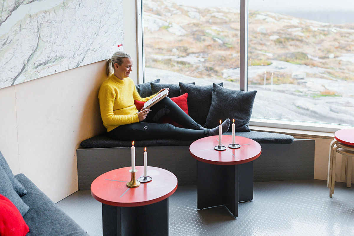 Nyt roen på en av våre fantastiske hytter i sommer. Her ser du den koselige sofakroken i hovedhytta på Skåpet.