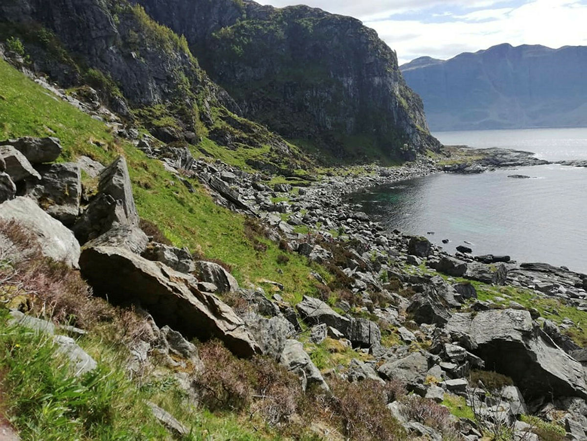 Stien går langs fjæresteinene, gjennom ura og over neset.