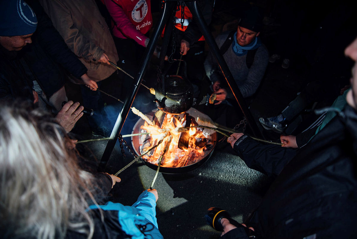 Bilde: en gruppe som steker pinnebrød på bålet.